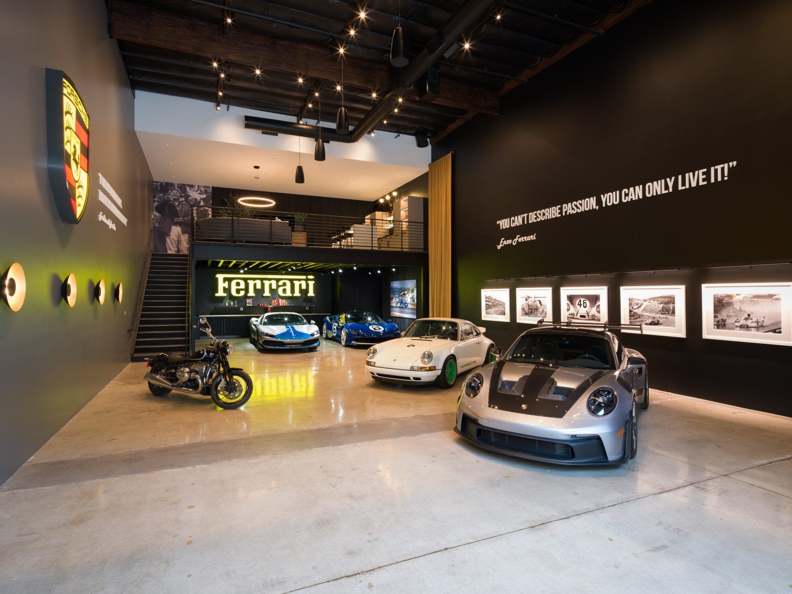 Garaža s nekoliko sportskih automobila, velikim natpisom Ferrari i potkrovljem.