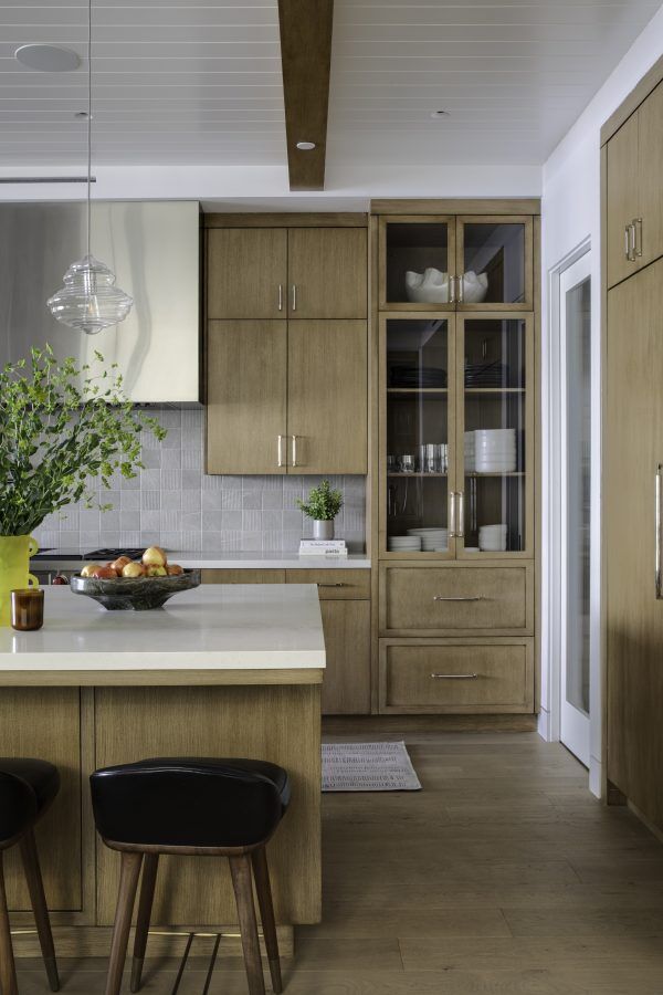 A kitchen with natural wood cabinets and white countertops.