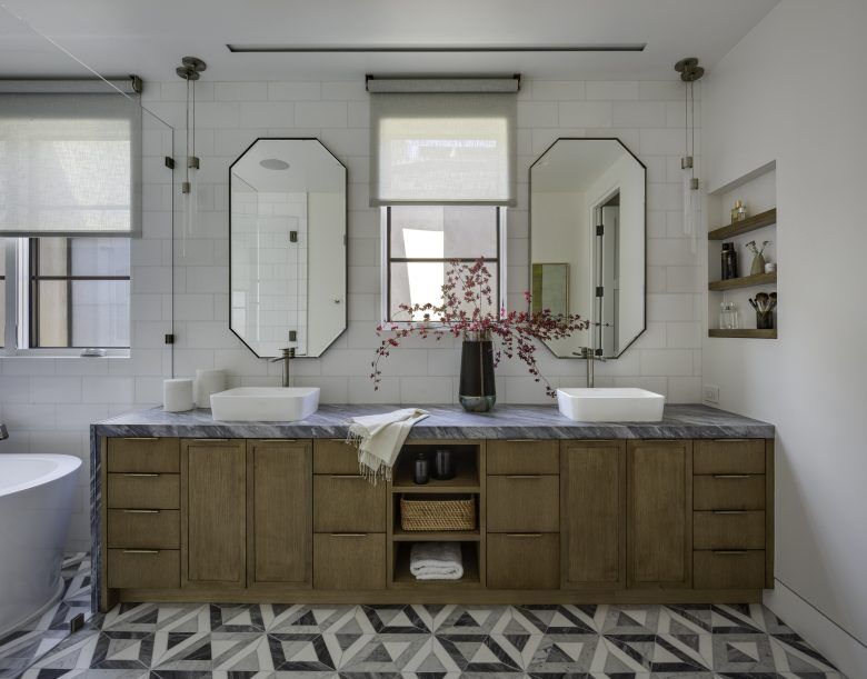 A white bathroom with natural cabinets and geometric tiling.